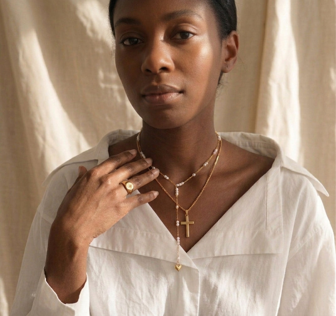 Collar de cruz dorada combinado con collar de perlas y corazón, estilo layering Aura Sacra
